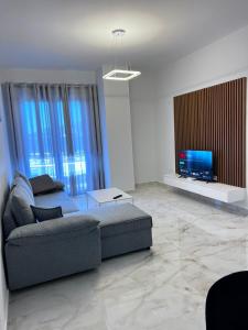 a living room with a couch and a flat screen tv at Prime Luxury Apartments in Lushnjë