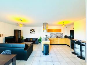 a kitchen and living room with a couch and a table at *Le Golden Tropic* Magnifique T4 Terrasse+Parking in Vaulx-en-Velin