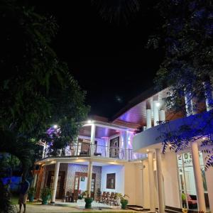 ein Gebäude mit lila Lichtern in der Nacht in der Unterkunft White Win Villa in Elewala