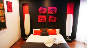 - une chambre avec un lit doté d'oreillers rouges et de roses dans l'établissement Apartamentos con jacuzzi, à Madrid