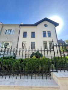 een wit huis achter een zwart hek bij Enjoy Apartments - Spacious Retreat in our Villa in Cluj-Napoca