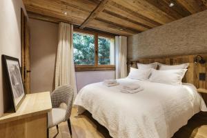 - une chambre avec un lit et des serviettes dans l'établissement Chalet Contemporain pour 12 personnes avec Sauna, à Vernaison