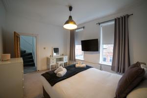 ein Schlafzimmer mit einem großen Bett mit zwei Kissen darauf in der Unterkunft Insurance Stays - Anfield L4 - Spacious house in Liverpool