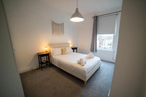 ein Schlafzimmer mit einem weißen Bett und einem Fenster in der Unterkunft Insurance Stays - Anfield L4 - Spacious house in Liverpool