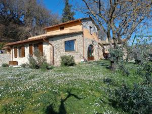 una pequeña casa de piedra en un campo de flores en La Piccola fattoria en Todi