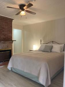 a bedroom with a bed with a ceiling fan at Auberge Les Sources in La Malbaie