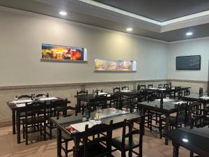 a restaurant with tables and chairs in a room at Hostal-Restaurante San Roque in Verín