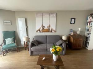 un soggiorno con un divano e un tavolo con fiori di Studio Front Mer a Le Touquet-Paris-Plage