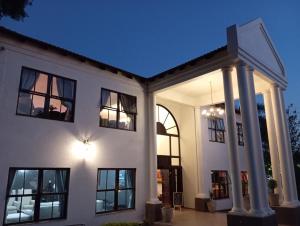 a white house with black windows and a light at Kloof in Pretoria