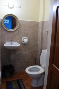 a bathroom with a toilet and a sink and a mirror at Caribbean Tourist Villa in Port-of-Spain