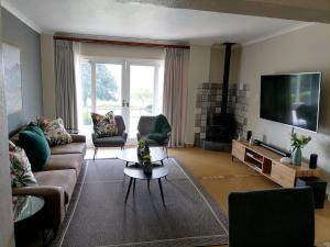a living room with a couch and a tv at Shingalana Cottages in White River