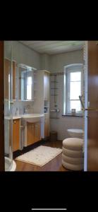 een badkamer met een wastafel, een bad en een raam bij FeWo Elisabeth am Harztor in Osterode