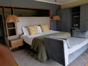 a bedroom with two beds and a chair at Shingalana Cottages in White River
