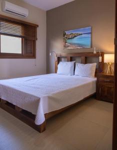 威廉斯塔德的住宿－Spanish Water View Apartment，一间卧室配有一张带白色床单的床和一扇窗户。