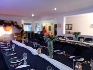 a long table with plates and a vase of flowers at Kloof in Pretoria