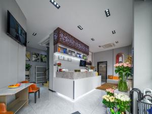 a lobby with a bar and a kitchen with orange chairs at Rose International Hotel in Shanghai