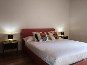 ein Schlafzimmer mit einem weißen Bett mit Kissen darauf in der Unterkunft Borgo dei vigneti in Montecarlo