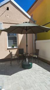 an umbrella on a patio with two chairs and a table at Apartman Arsić Zajecar in Zaječar