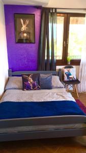 purpurowa sypialnia z łóżkiem z fioletową ścianą w obiekcie Dom Górski - cały na wyłączność w Szklarskiej Porębie