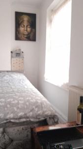 een slaapkamer met een bed, een raam en een toetsenbord bij Bromley Cosy in Bromley