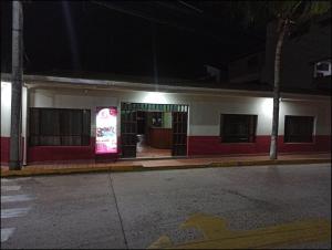 un edificio con un cartello rosa sul lato di COE RURRENABAQUE a Rurrenabaque