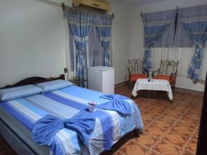 1 dormitorio con 1 cama con manta azul y blanca en COE RURRENABAQUE, en Rurrenabaque