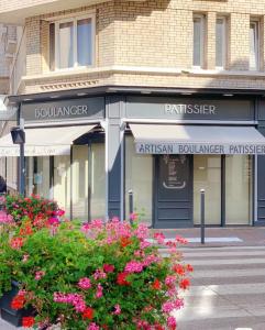 a building on a street with flowers in front of it at Paradis de Vanves in Vanves