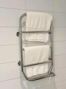 um toalheiro na casa de banho com toalhas brancas em Where every stay is a story 