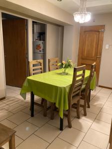 una mesa de comedor con un mantel verde. en Departamento Lemos en Mendoza