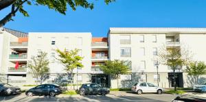 a parking lot with cars parked in front of a building at *Le Golden Tropic* Magnifique T4 Terrasse+Parking in Vaulx-en-Velin