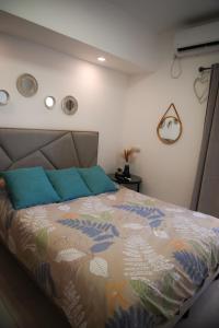 een slaapkamer met een bed met blauwe kussens bij Almog Suite in Eilat close to Red Sea - דירת נופש אלמוג מרחק נגיעה מהים in Eilat