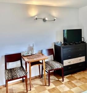 a room with a table and two chairs and a television at Pokoje na Zaciszu - Metro Zacisze in Warsaw