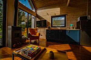 una cucina e un soggiorno in una casa di POCZUJ NATURĘ - domki nad jeziorem a Stare Wierzchowo Altre 40 foto