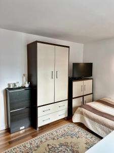 a bedroom with a large white cabinet and a television at Pokoje na Zaciszu - Metro Zacisze in Warsaw