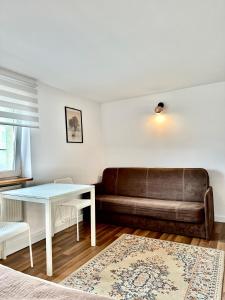 ein Wohnzimmer mit einem Sofa und einem Tisch in der Unterkunft Pokoje na Zaciszu - Metro Zacisze in Warschau