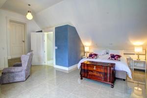 a bedroom with a bed and a chair and a desk at Buffelsdam Country House in The Crags