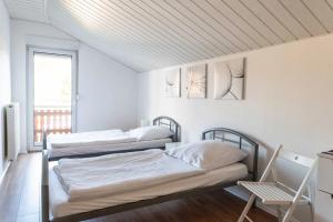 2 camas en una habitación blanca con ventana en Ferienhaus Steinhoff, en Marsberg