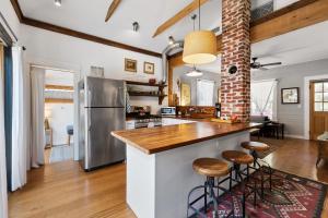 a kitchen with a large counter and stools at a bar at Cape Keepers Cottage - Lighthouse Park in Saint Augustine