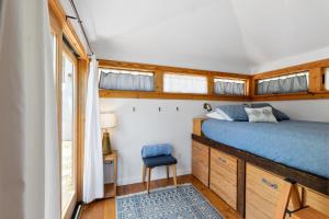 a bedroom with a blue bed and a chair at Cape Keepers Cottage - Lighthouse Park in Saint Augustine