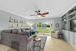 Una sala de estar con un sofá y un ventilador de techo. en Island Oasis - 3br 2ba - steps to the ocean!, en St. Augustine
