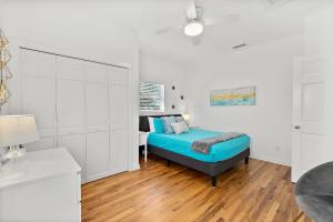 um quarto branco com uma cama e um armário branco em The Old Mission Collection - Downtown Bungalow em Saint Augustine