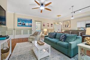 sala de estar con sofá azul y cocina en The Ray- 1st Floor Charming Condo- Walk to Downtown en St. Augustine