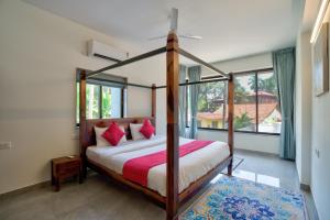 a bedroom with a canopy bed and a large window at Lavish 2BHK Apartment with Swimming Pool in Candolim in Candolim