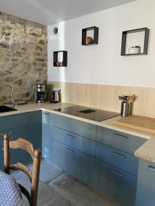 una cocina con armarios azules y fregadero en Erquy Les Hirondelles, en Erquy