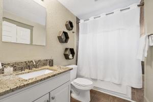 Un baño con inodoro, lavabo y ducha. en The Ray- 1st Floor Charming Condo- Walk to Downtown, en St. Augustine 31 fotos más