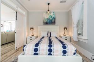 a white bedroom with a large bed and two night stands at 20 Hypolita - Luxury Downtown Apartment in Saint Augustine