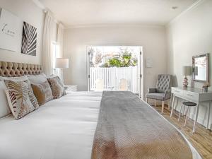 セント・オーガスティンにあるPrivate Romantic Retreat Mins DWTN Beachの白い大きなベッドルーム(大型ベッド1台、デスク付)