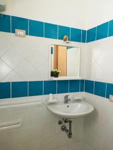 uma casa de banho com um lavatório, um espelho e uma banheira em Villaggio Residence Villamarina em Marina di Camerota