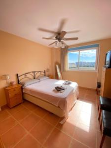 um quarto com uma cama e uma ventoinha de tecto em Río Palancia, Disfruta de una estancia en Familia em Oropesa del Mar