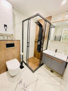 uma casa de banho com um chuveiro, um WC e um lavatório. em Hidden treasure em Varna City